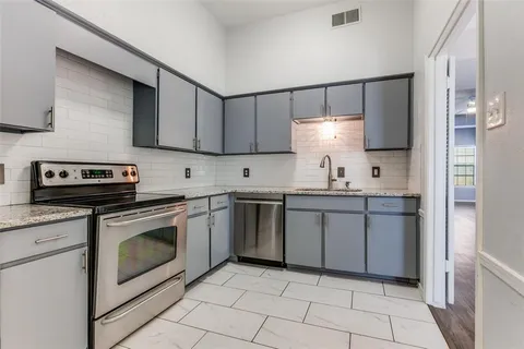 a kitchen with a stove sink and cabinets