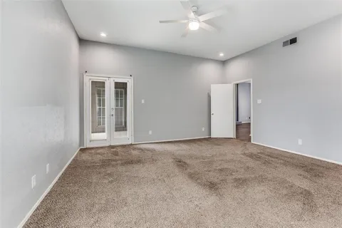 an empty room with a ceiling fan and a window