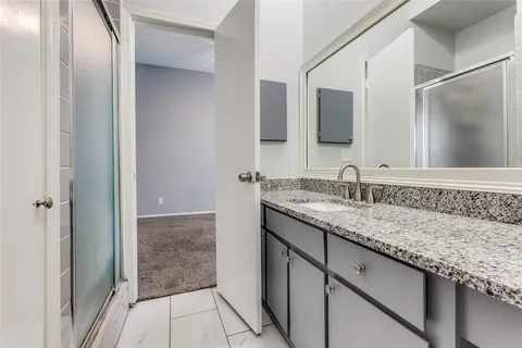 a bathroom with a granite countertop sink and a mirror