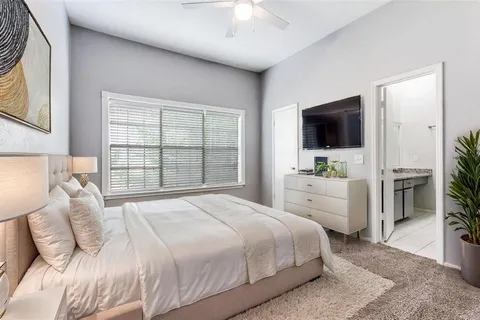 a bedroom with a large bed and a flat screen tv