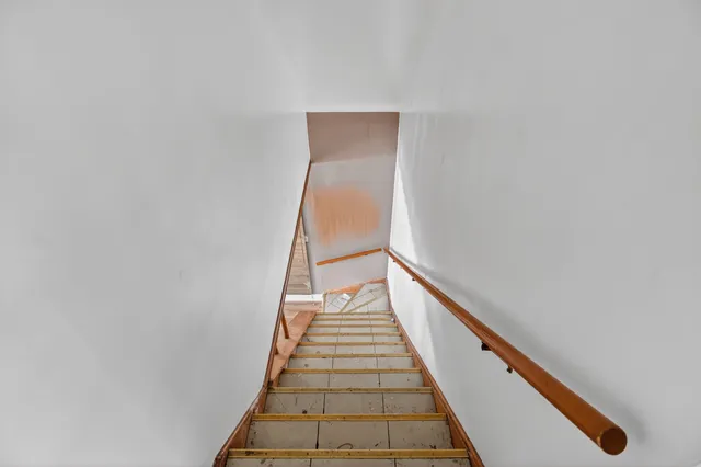 a view of hallway with livingroom and wooden floor