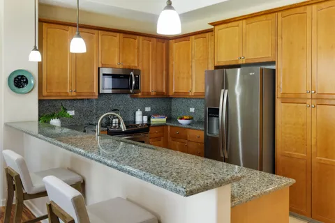 a kitchen with stainless steel appliances granite countertop a sink refrigerator and microwave