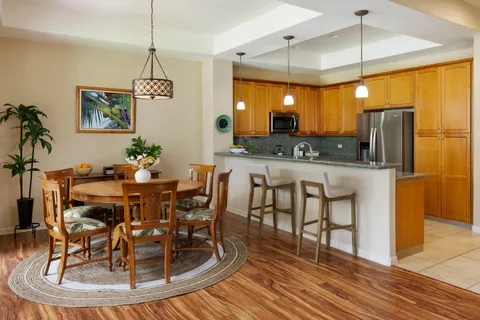 a dining room filled chandelier and wooden floor