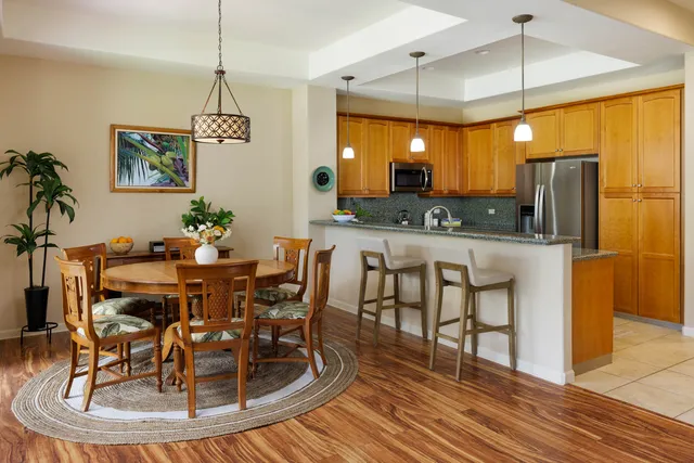 a dining room filled chandelier and wooden floor