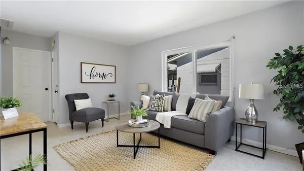 a living room with furniture and a potted plant