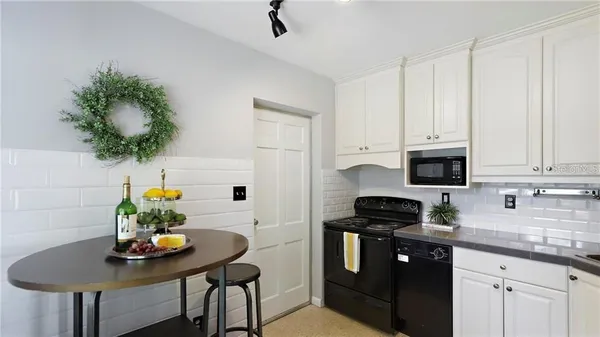 a kitchen with stainless steel appliances a table chairs and a refrigerator