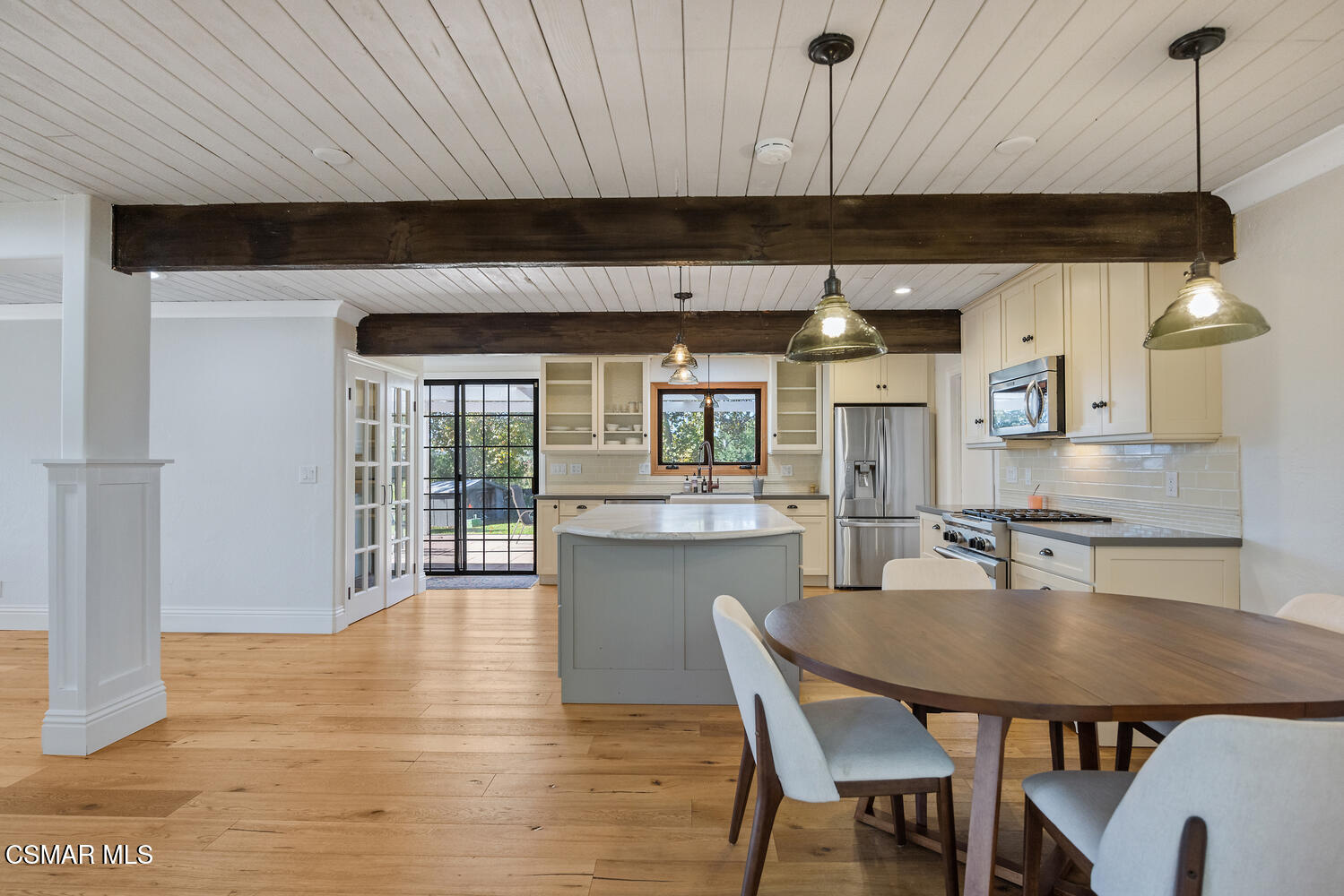 11316 Barranca Road Camarillo, CA 93012 - Photo 15 of 44 a kitchen with stainless steel appliances granite countertop a stove top oven a dining table and chairs with wooden floor