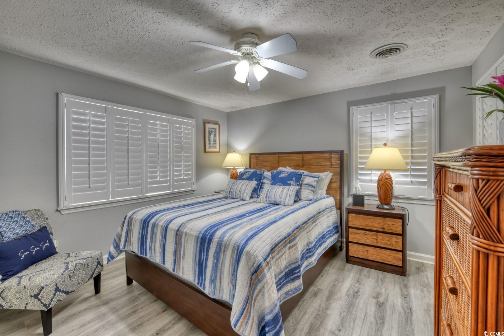 3714 Jordan Landing Road Murrells Inlet, SC 29576 - Photo 11 of 39 Bedroom featuring wood finished floors, a textured ceiling, and ceiling fan