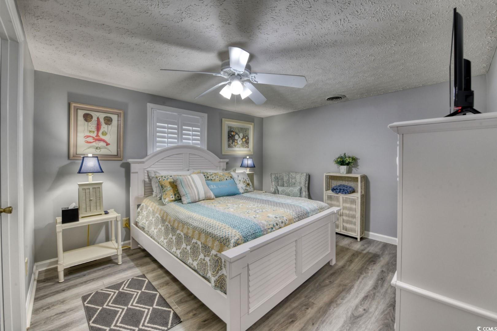 3714 Jordan Landing Road Murrells Inlet, SC 29576 - Photo 12 of 39 Bedroom featuring a textured ceiling, light wood-type flooring, and a ceiling fan