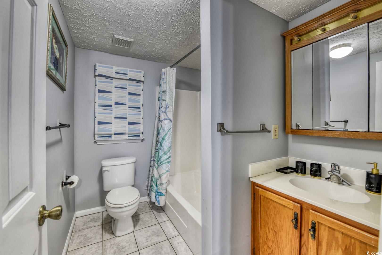 3714 Jordan Landing Road Murrells Inlet, SC 29576 - Photo 13 of 39 Full bathroom with a textured ceiling, shower / bath combo with shower curtain, light tile patterned flooring, and vanity