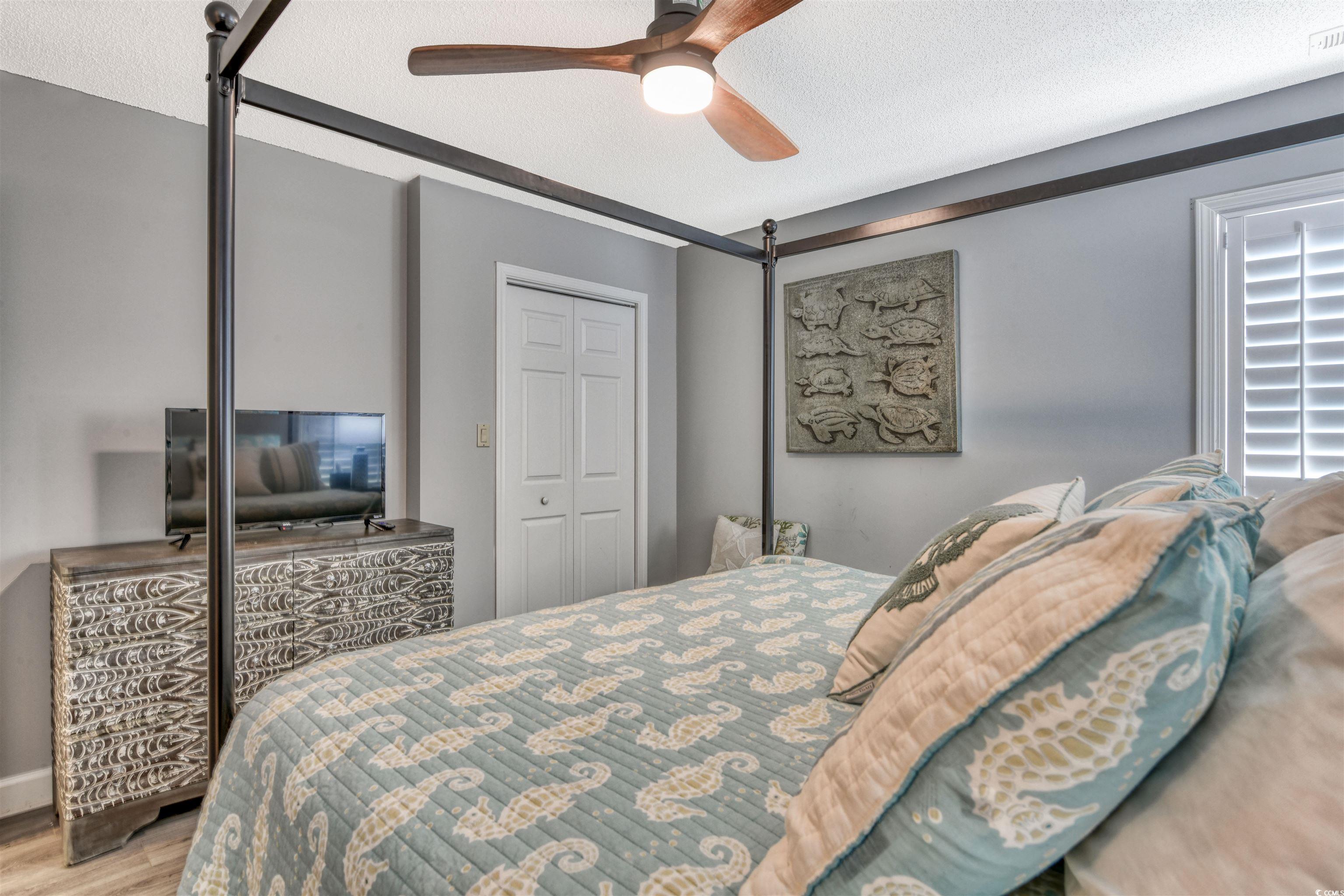 3714 Jordan Landing Road Murrells Inlet, SC 29576 - Photo 21 of 39 Bedroom featuring wood finished floors, a closet, a textured ceiling, and a ceiling fan