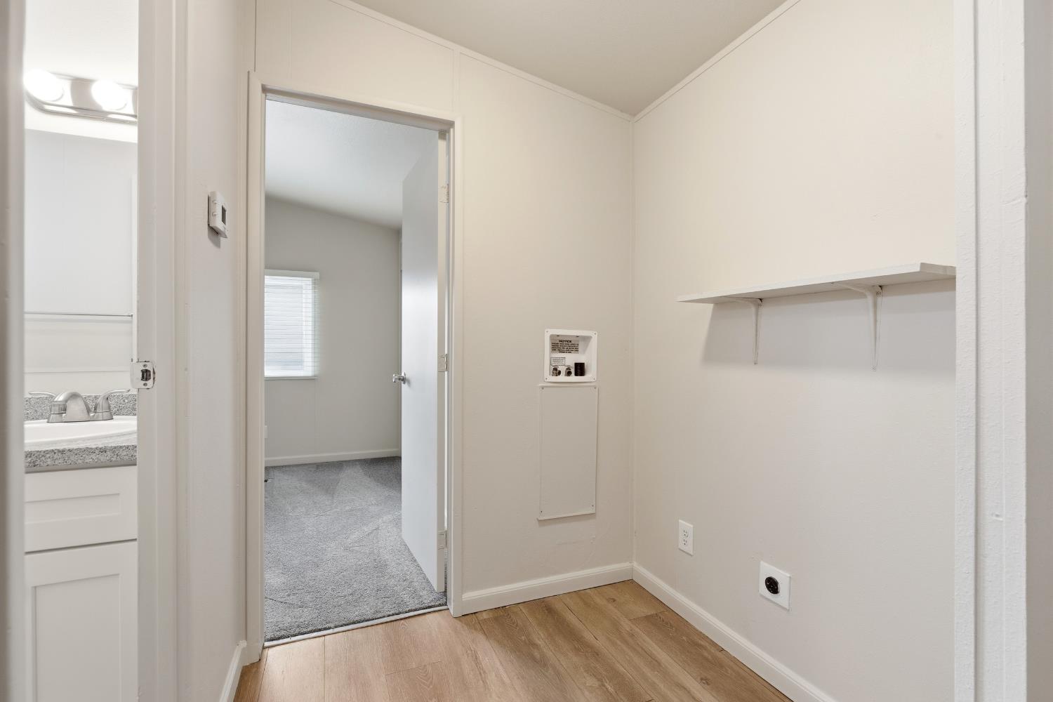 2307 Oakdale Road, Unit 15 Modesto, CA 95355 - Photo 11 of 17 an empty room with wooden floor and mirror
