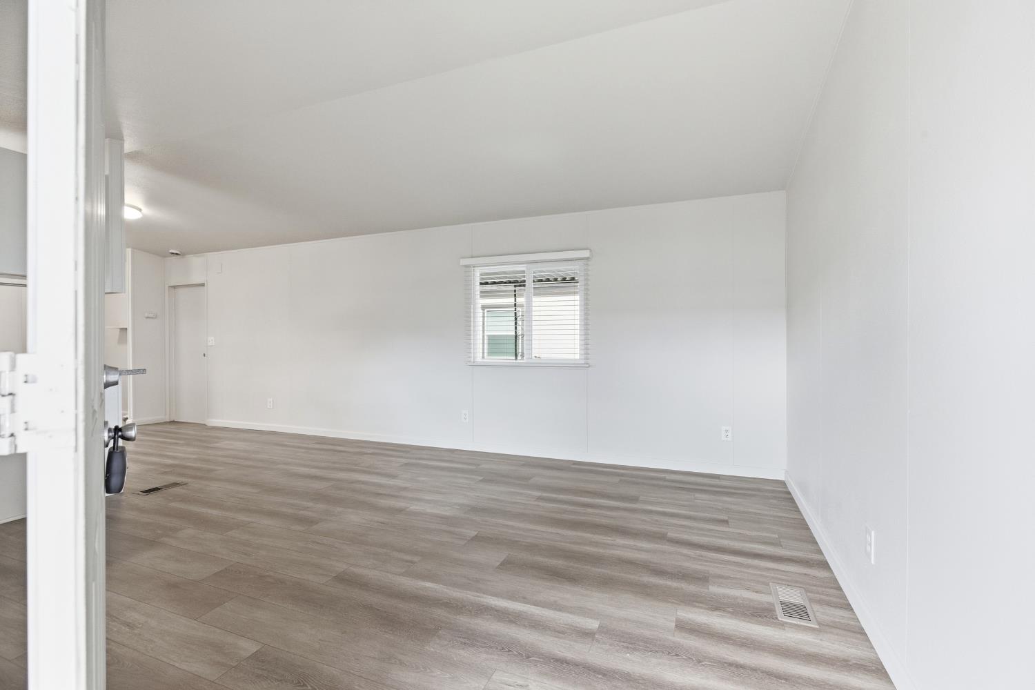 2307 Oakdale Road, Unit 15 Modesto, CA 95355 - Photo 5 of 17 a view of an empty room with wooden floor and a window