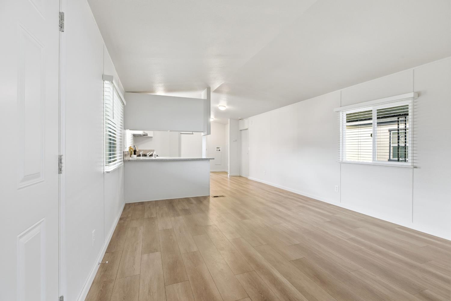 2307 Oakdale Road, Unit 15 Modesto, CA 95355 - Photo 7 of 17 a view of empty room with wooden floor and kitchen
