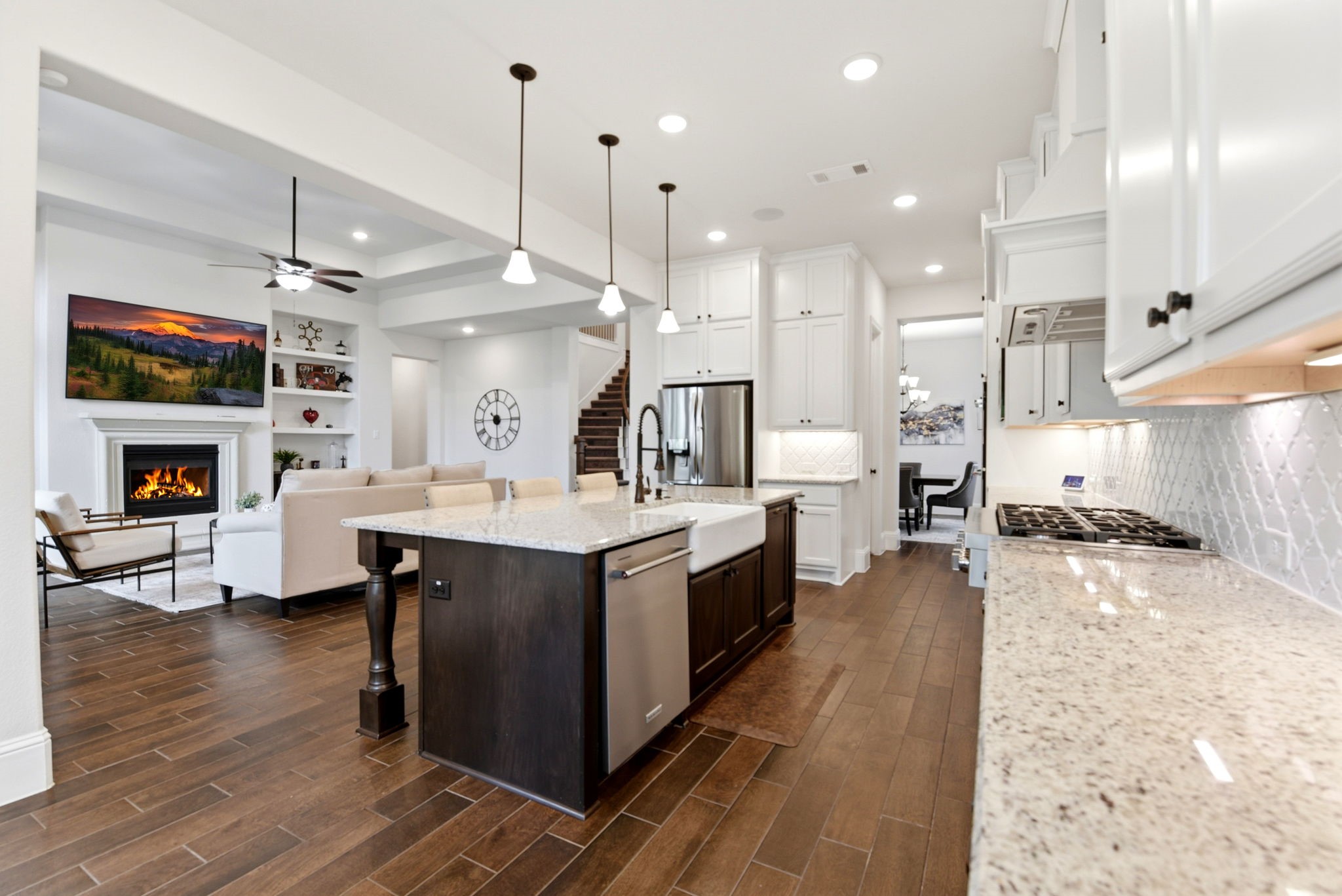 10062 South Goshawk Trail Conroe, TX 77385 - Photo 12 of 43 a large kitchen with kitchen island a island a stove a sink a center island and a wooden floor
