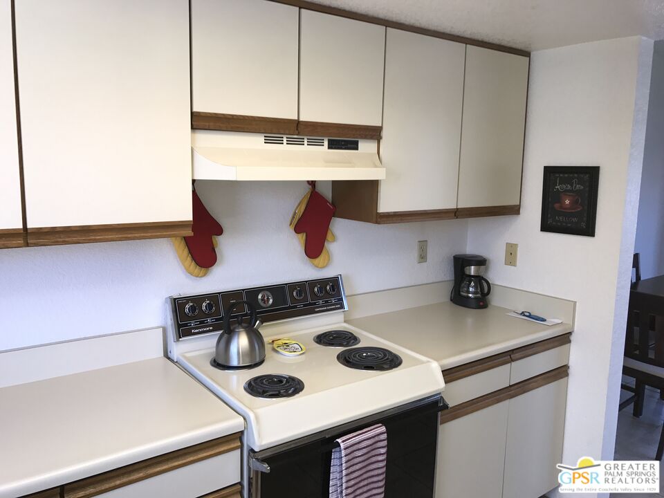 2701 East Mesquite Avenue, Unit GG180 Palm Springs, CA 92264 - Photo 11 of 26 a kitchen with a stove and a table