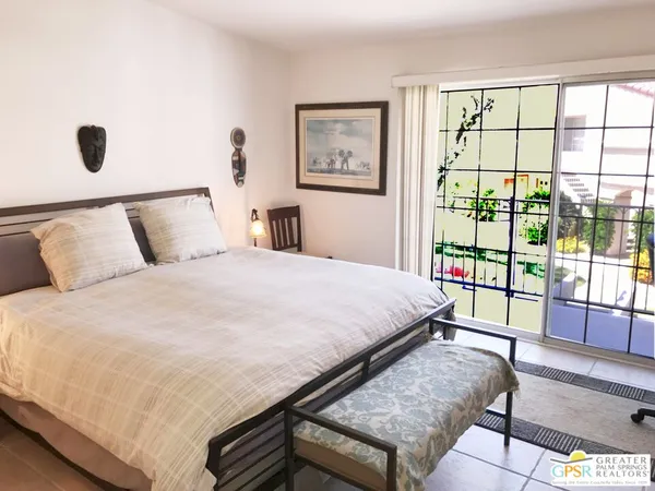 a large bed sitting in a bedroom next to a window