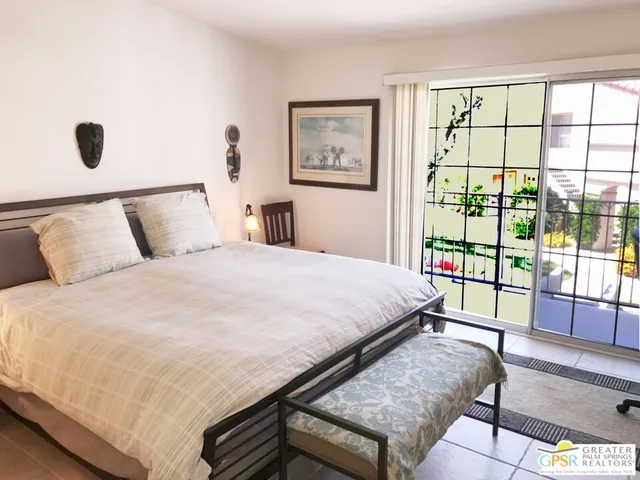 a large bed sitting in a bedroom next to a window