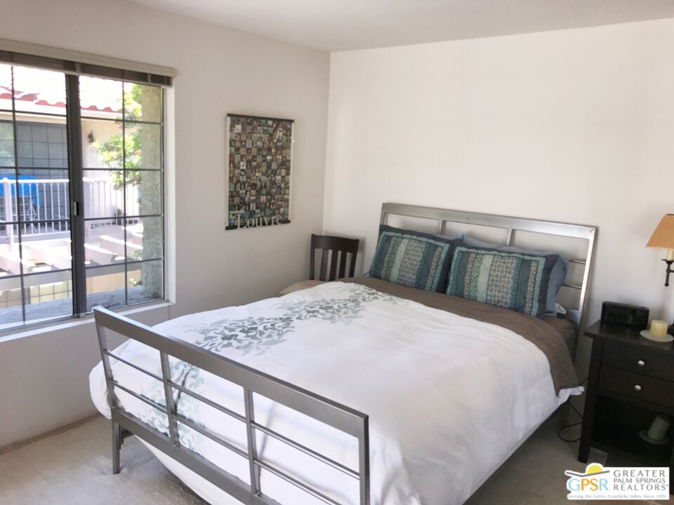 2701 East Mesquite Avenue, Unit GG180 Palm Springs, CA 92264 - Photo 17 of 26 a bedroom with a bed and wooden floor