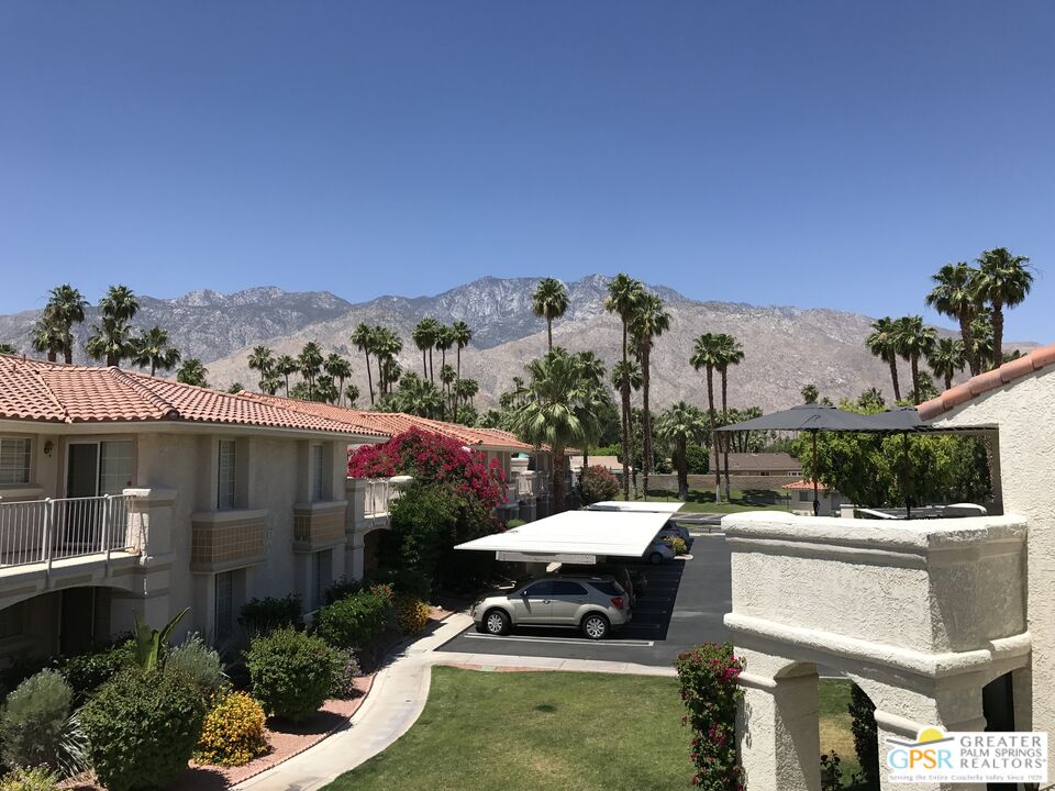 2701 East Mesquite Avenue, Unit GG180 Palm Springs, CA 92264 - Photo 6 of 26 a view of a patio with couches table and chairs under an umbrella
