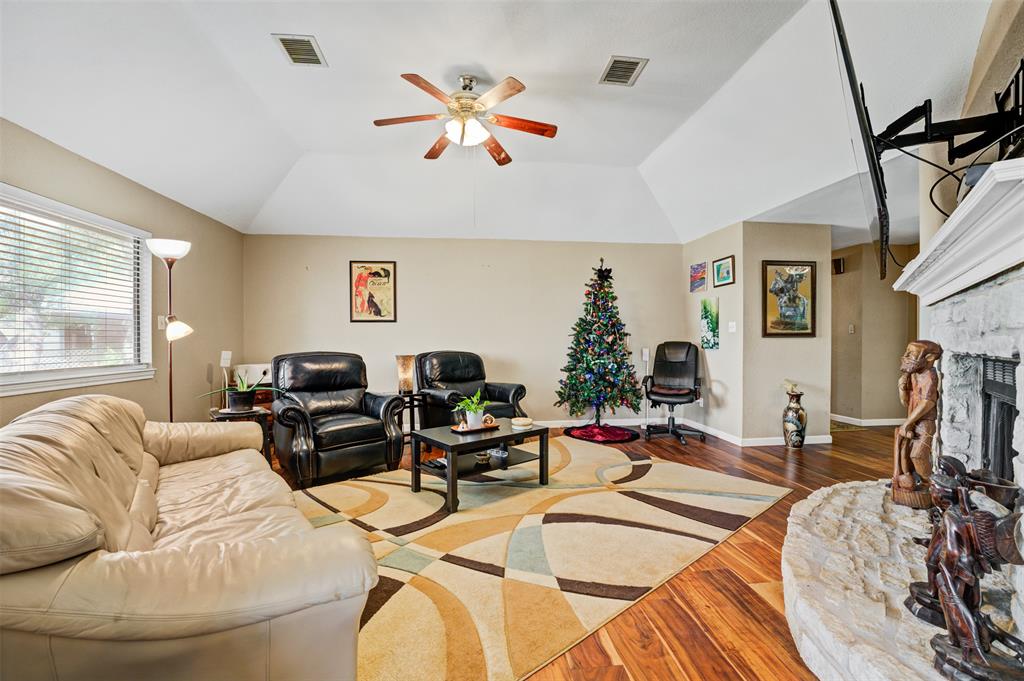 21013 Ridgeview Loop Lago Vista, TX 78645 - Photo 5 of 16 Living room featuring dark wood finished floors, a stone fireplace, vaulted ceiling, and ceiling fan