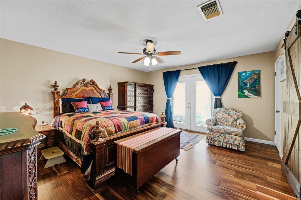 21013 Ridgeview Loop Lago Vista, TX 78645 - Photo 8 of 16 Bedroom featuring a barn door to bathroom area, access to exterior