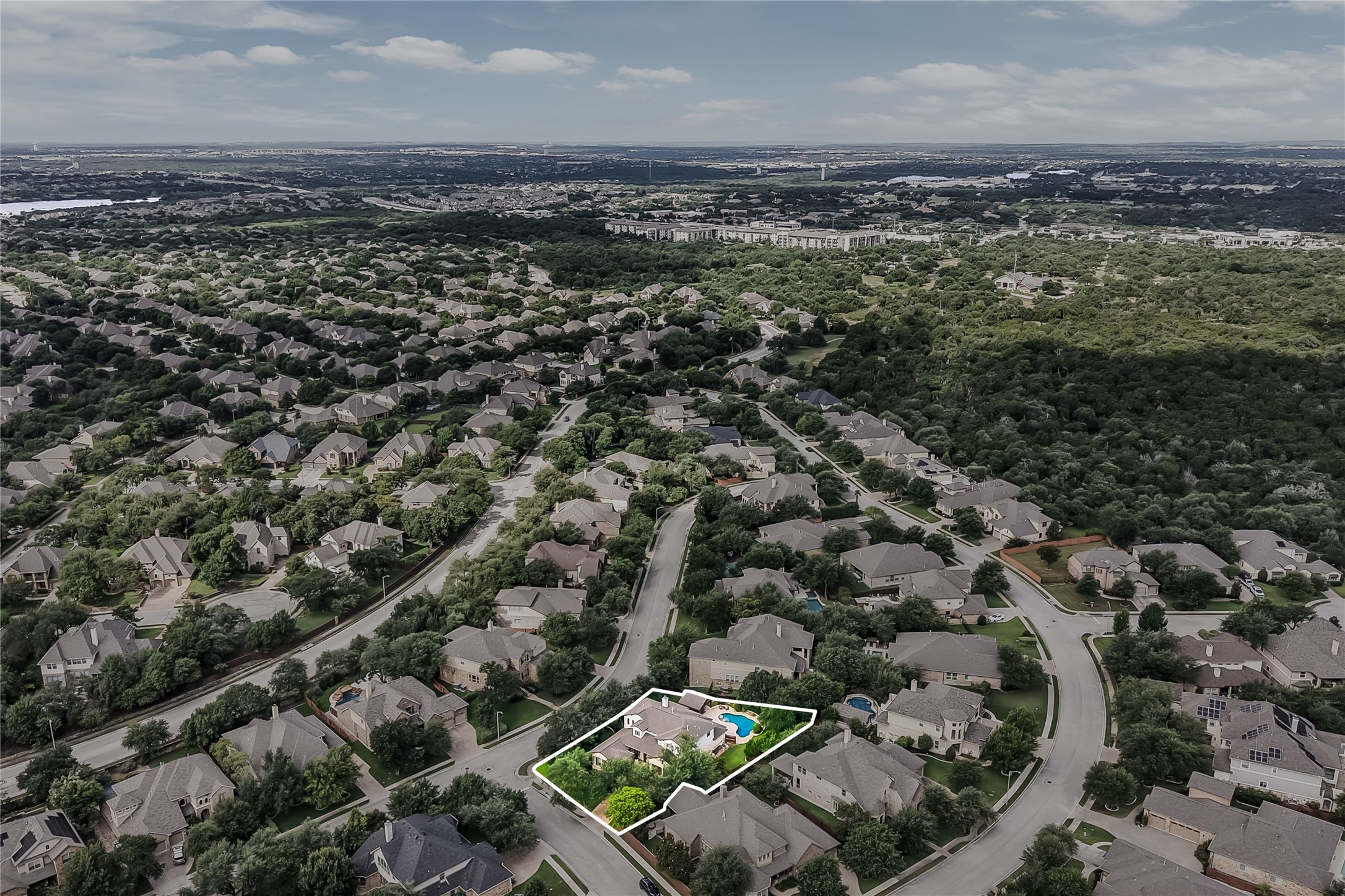 401 Bluff View Road Cedar Park, TX 78613 - Photo 40 of 40 An aerial perspective reveals a vibrant neighborhood with a home featuring a sparkling pool, nestled among lush greenery.