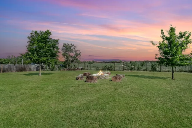 a view of a green field with trees