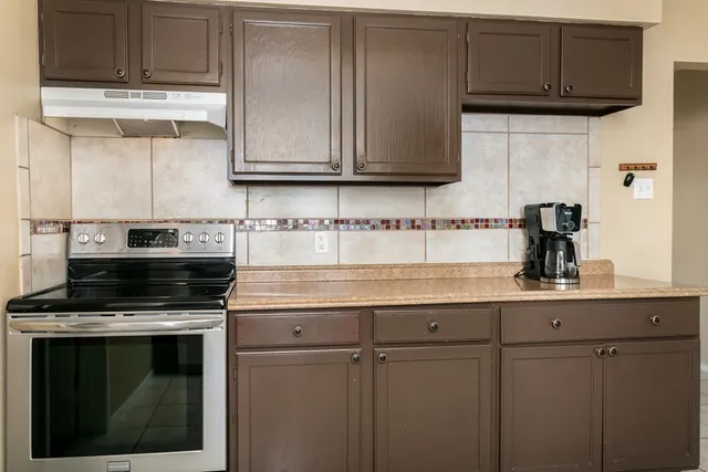 a kitchen with stainless steel appliances granite countertop a stove a microwave and cabinets