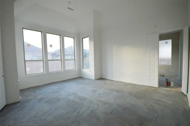 an empty room with windows and closet