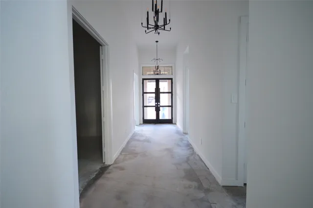 a view of a hallway with windows and chandelier