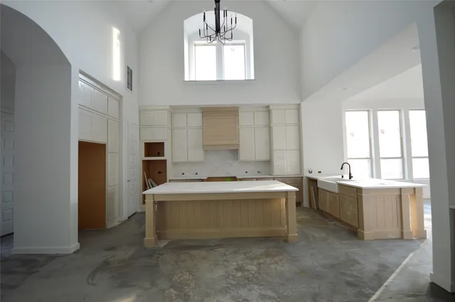 a large white kitchen with a stove a sink dishwasher and a refrigerator