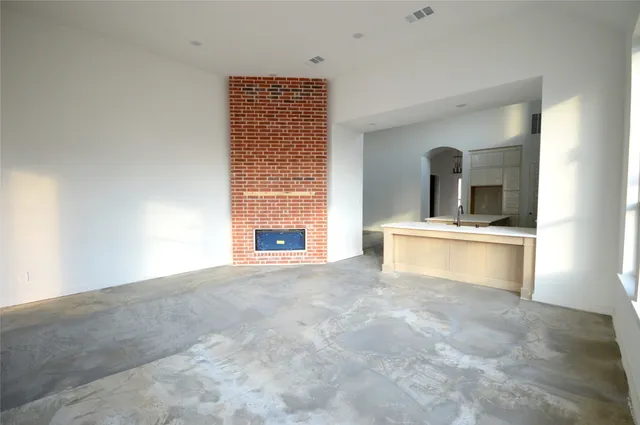 a view of an empty room with a fireplace and a window