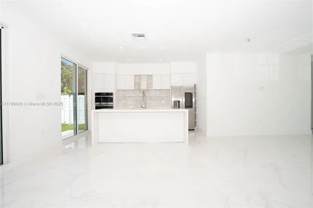 a white kitchen with stainless steel appliances