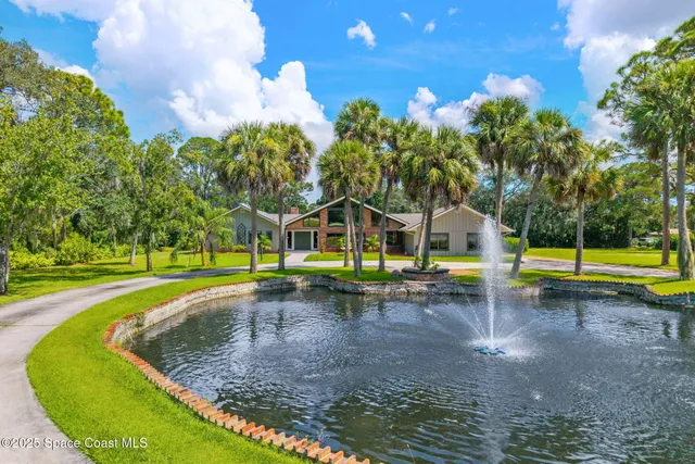 a view of a swimming pool with a yard and sitting area