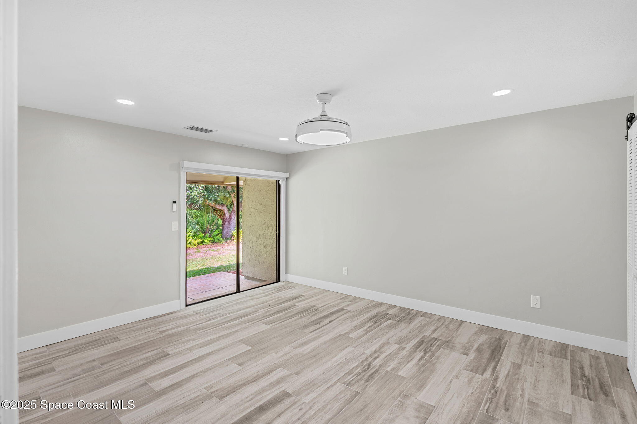 2187 Turtle Mound Road Melbourne, FL 32934 - Photo 25 of 77 wooden floor in an empty room with a window