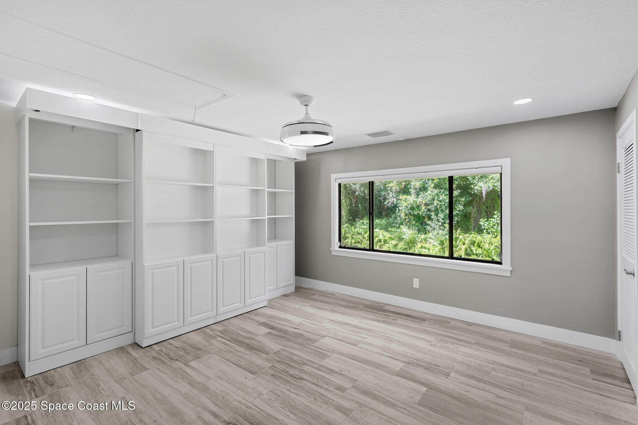 2187 Turtle Mound Road Melbourne, FL 32934 - Photo 26 of 77 a view of an empty room with a window and wooden floor