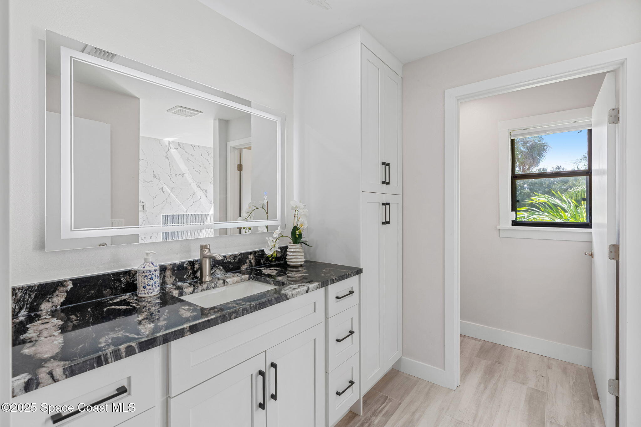 2187 Turtle Mound Road Melbourne, FL 32934 - Photo 40 of 77 a bathroom with a sink and a mirror