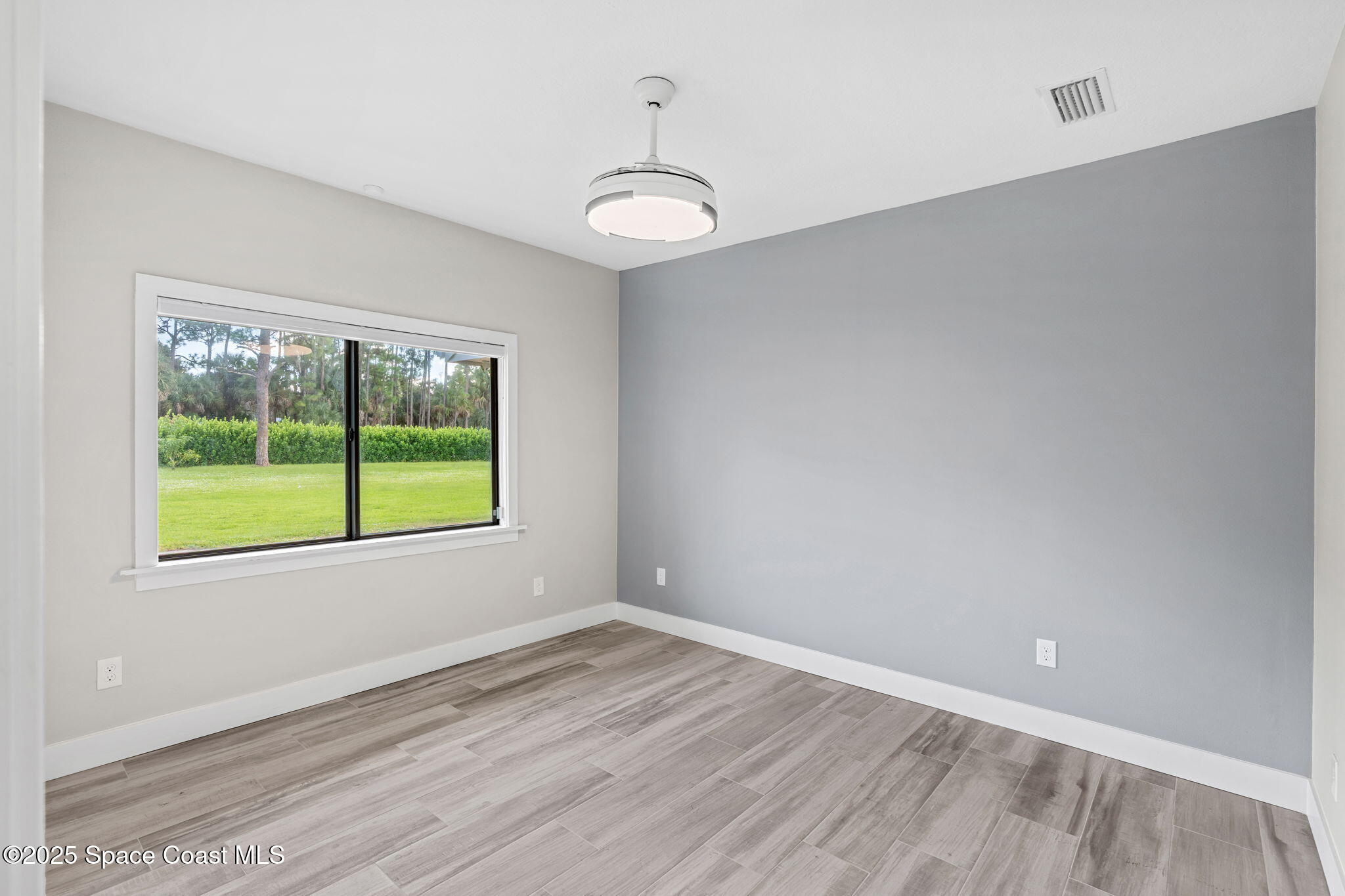 2187 Turtle Mound Road Melbourne, FL 32934 - Photo 46 of 77 a view of an empty room with wooden floor and a window