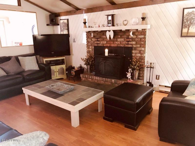 148 Roundhill Road Dingmans Ferry, PA 18328 - Photo 2 of 24 a living room with furniture a flat screen tv and a fireplace