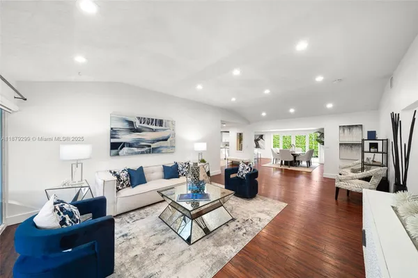 a living room with furniture kitchen view and a table