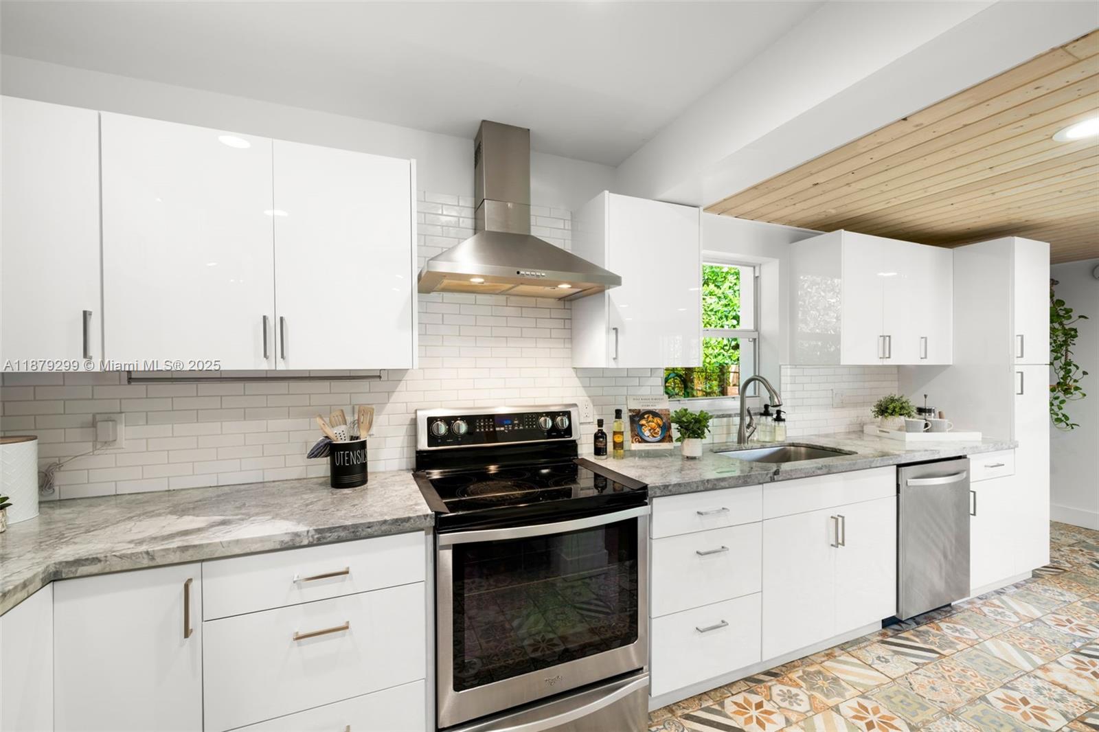 475 Northwest 88th Terrace El Portal, FL 33150 - Photo 11 of 33 a kitchen with stainless steel appliances a stove a sink and cabinets