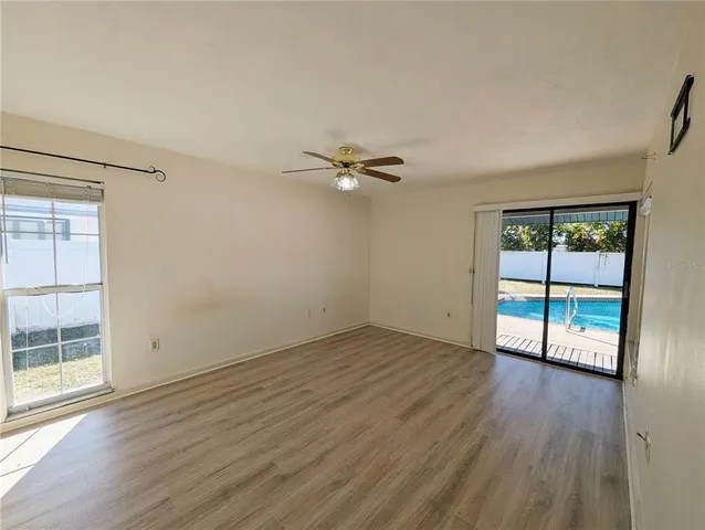 a view of an empty room with a window and wooden floor