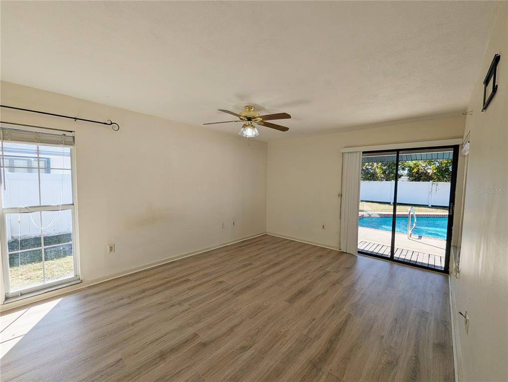1329 Pine Needle Road Venice, FL 34285 - Photo 12 of 43 an empty room with wooden floor and windows