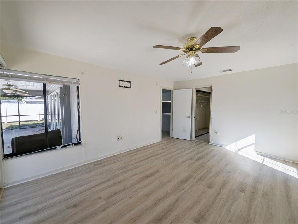 1329 Pine Needle Road Venice, FL 34285 - Photo 13 of 43 a view of an empty room with a window and wooden floor