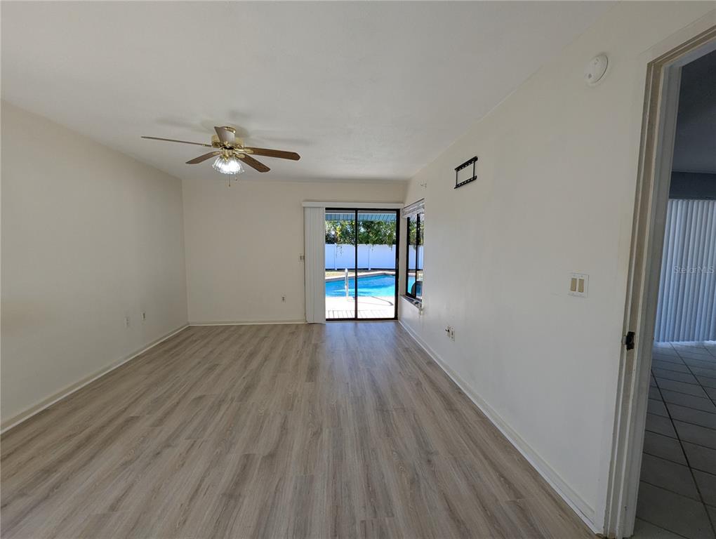 1329 Pine Needle Road Venice, FL 34285 - Photo 16 of 43 wooden floor in an empty room with a window