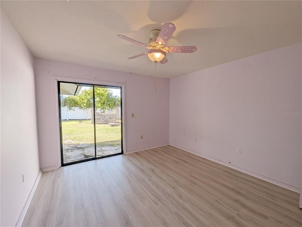 1329 Pine Needle Road Venice, FL 34285 - Photo 21 of 43 an empty room with wooden floor fan and windows