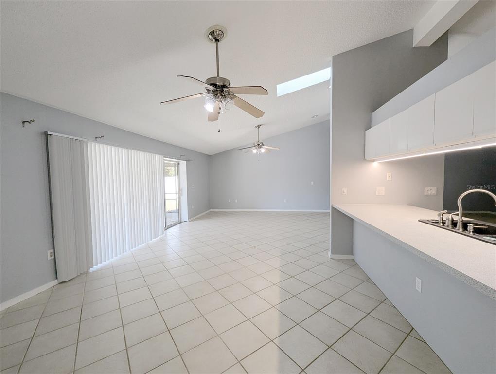 1329 Pine Needle Road Venice, FL 34285 - Photo 22 of 43 a large white kitchen with a sink and chandelier