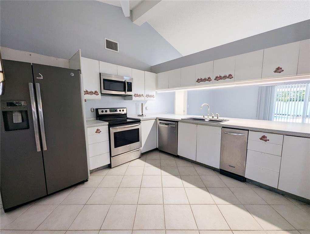 1329 Pine Needle Road Venice, FL 34285 - Photo 23 of 43 a kitchen with stainless steel appliances granite countertop a stove a sink and a refrigerator