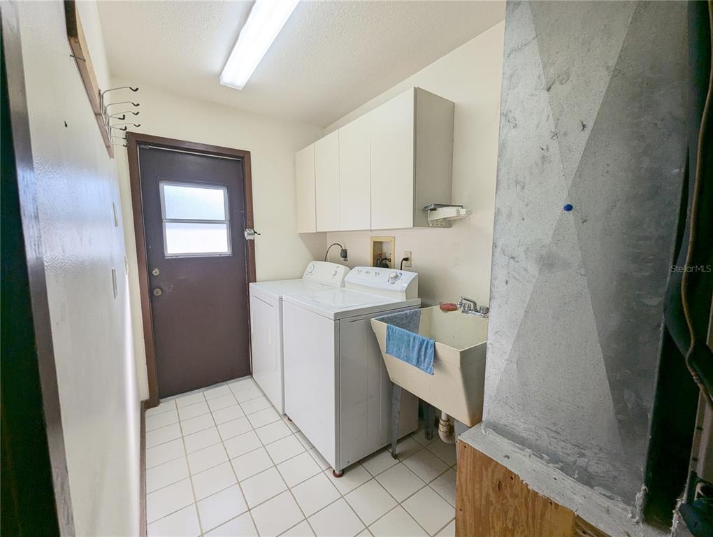 1329 Pine Needle Road Venice, FL 34285 - Photo 24 of 43 a utility room with a sink a washer and dryer